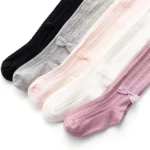 Display of custom baby tights in multiple colors, featuring vertical ribbed knit patterns and charming ankle bow accents. High-quality soft cotton infant pantyhose from a professional OEM/ODM manufacturer in China.