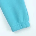 Close-up of baby joggers leg cuff detail, featuring soft-stretch elasticized opening, high-quality breathable cotton fleece fabric, and precision seam finishing. Premium infant sweatpants craftsmanship from a professional clothing factory.