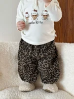 Lifestyle shot of baby wearing custom leopard print joggers, featuring a trendy harem silhouette, elastic waistband, and all-over animal pattern. High-quality infant sweatpants from a professional OEM/ODM clothing manufacturer.