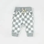 Custom mint green baby joggers featuring a trendy checkerboard print, durable elastic waistband with natural cotton drawstring, and ribbed cuffs. High-quality infant sweatpants from a professional OEM/ODM clothing manufacturer in China.