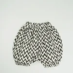 Custom black and white chevron baby bloomers, featuring a trendy zigzag print, voluminous bubble silhouette, and comfortable elastic waistband. High-quality infant diaper cover shorts from a professional OEM/ODM clothing manufacturer.