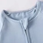 Close-up of baby romper safety chin guard, featuring a protective fabric tab covering the front zipper slider and a smooth ribbed crew neck. Premium safe-design infant apparel from a professional clothing manufacturer.