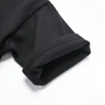 Precision double-needle coverstitch on black heavyweight T-shirt sleeve, clean hem finishing from a professional OEM/ODM clothing manufacturer, durable premium cotton apparel construction.