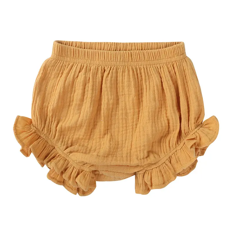 Custom mustard yellow baby bloomers with elegant ruffle trim, premium breathable muslin cotton diaper cover, stylish double gauze infant shorts from a professional OEM/ODM kids clothing manufacturer.