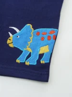 Close-up of baby navy shorts print detail, featuring a vibrant blue and orange dinosaur graphic and precise double-needle hem stitching. High-quality infant boy's graphic apparel from a professional clothing manufacturer.