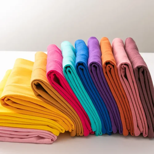 这张图片展示了一叠色彩缤纷、整齐叠放的素色男士 T 恤。作为 B2B 展示，这张图非常适合体现工厂的面料现货颜色库（Color Library）、染色工艺以及**大规模定制（Bulk Production）**的供应链优势。 以下是为您定制的 SEO 优化方案： 1. 替代文本 (Alt Text) 建议： 强调丰富的颜色选择和面料种类。 Custom mens T-shirts in various colors, stacked blank cotton tee shirts, professional wholesale garment dyeing service, high-quality OEM/ODM T-shirt manufacturer.